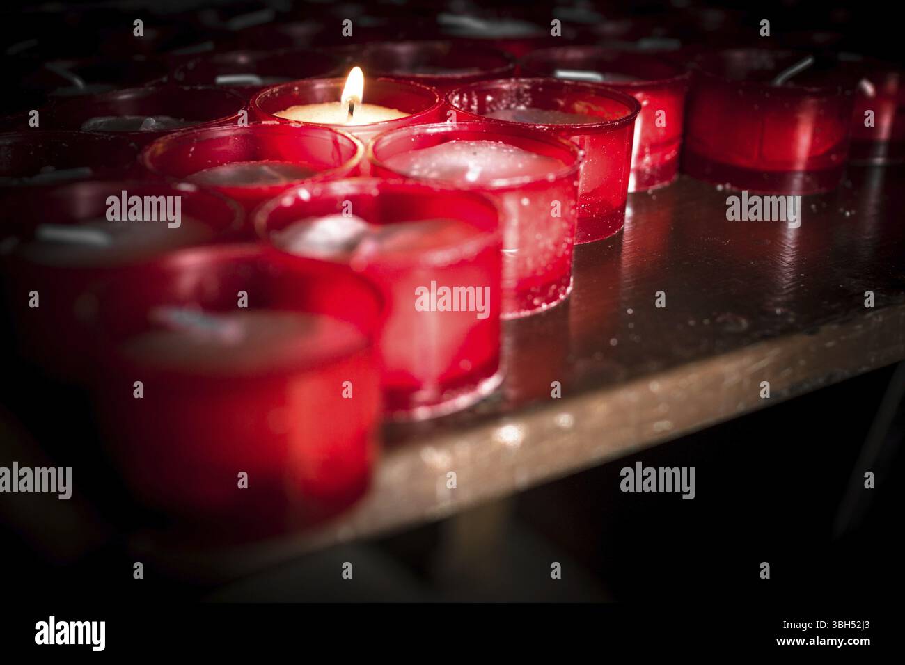 Gruppo di candele rosse in una chiesa Foto Stock