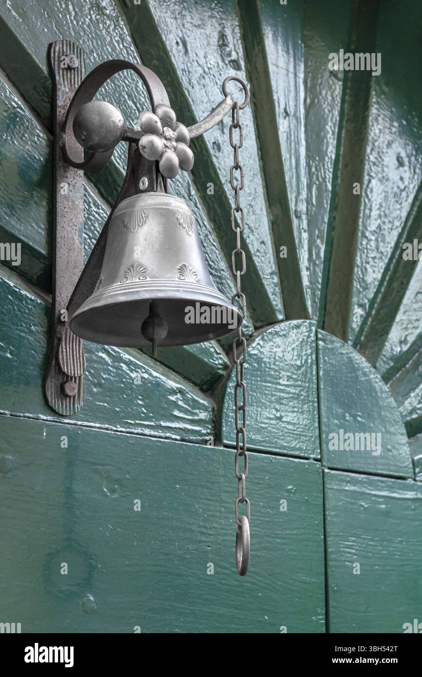 Campanella in vecchio stile come campanello su porta verde in legno Foto Stock