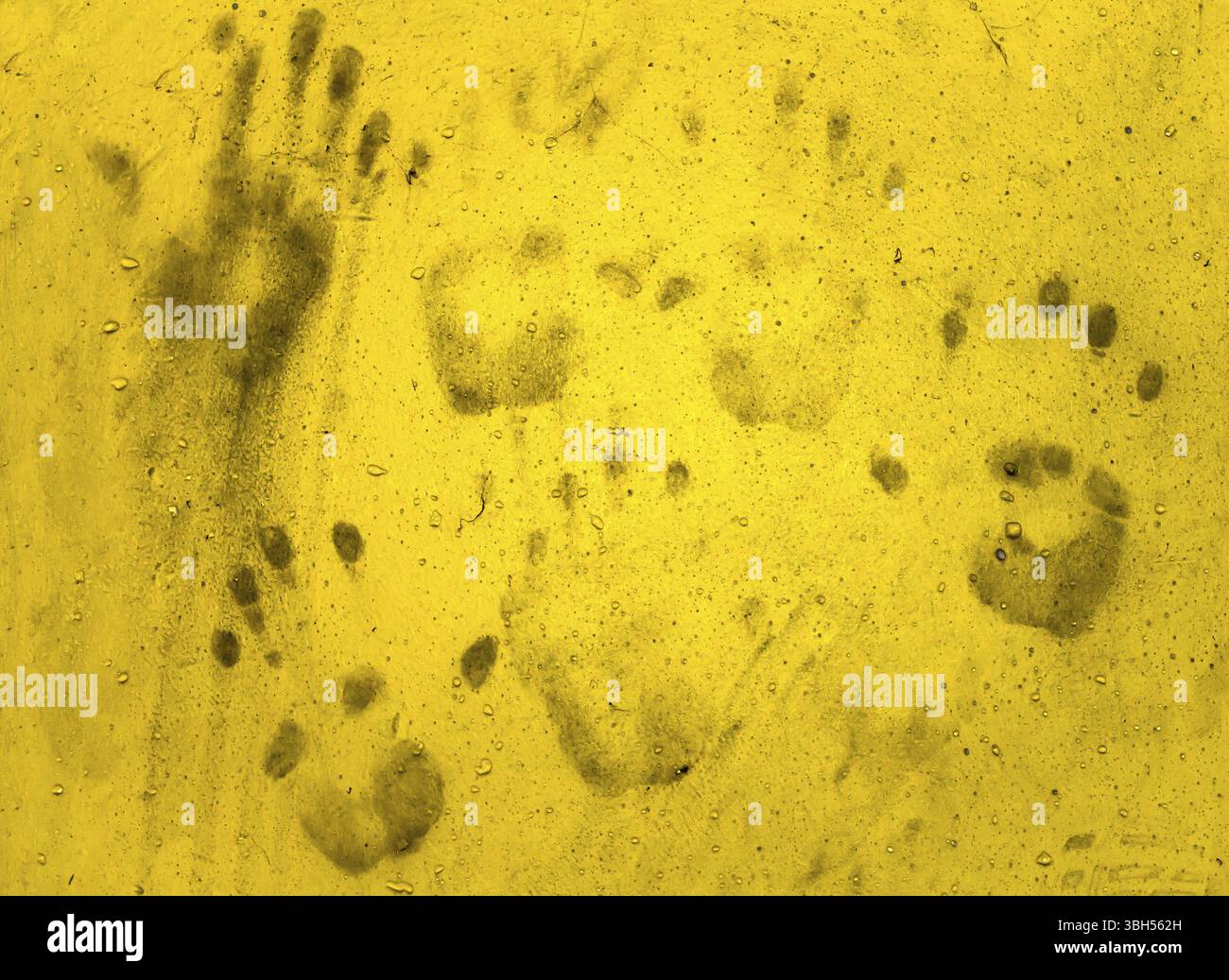 Mano sporca stampe su muro giallo. Idee per Halloween di sfondo Foto Stock