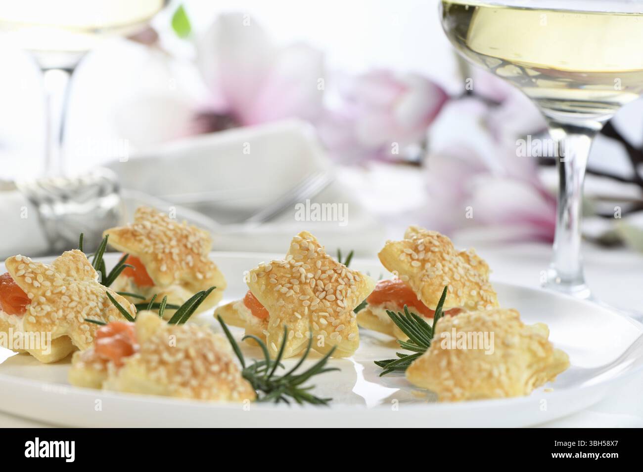 Antipasto natalizio di pasta sfoglia a forma di stella, ripieno di salmone e formaggio morbido. L'antipasto perfetto per il vostro tavolo di vacanza Foto Stock