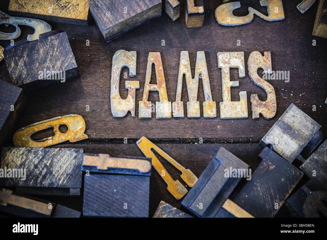 I GIOCHI di parole scritti in lettere di metallo arrugginito circondati da letterpress vintage in legno e metallo Foto Stock