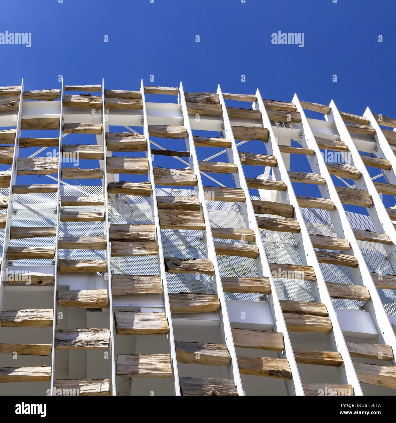 Edificio moderno decorato con tronchi di legno. Eccelle il contrasto tra lo stile moderno e gli elementi della natura Foto Stock