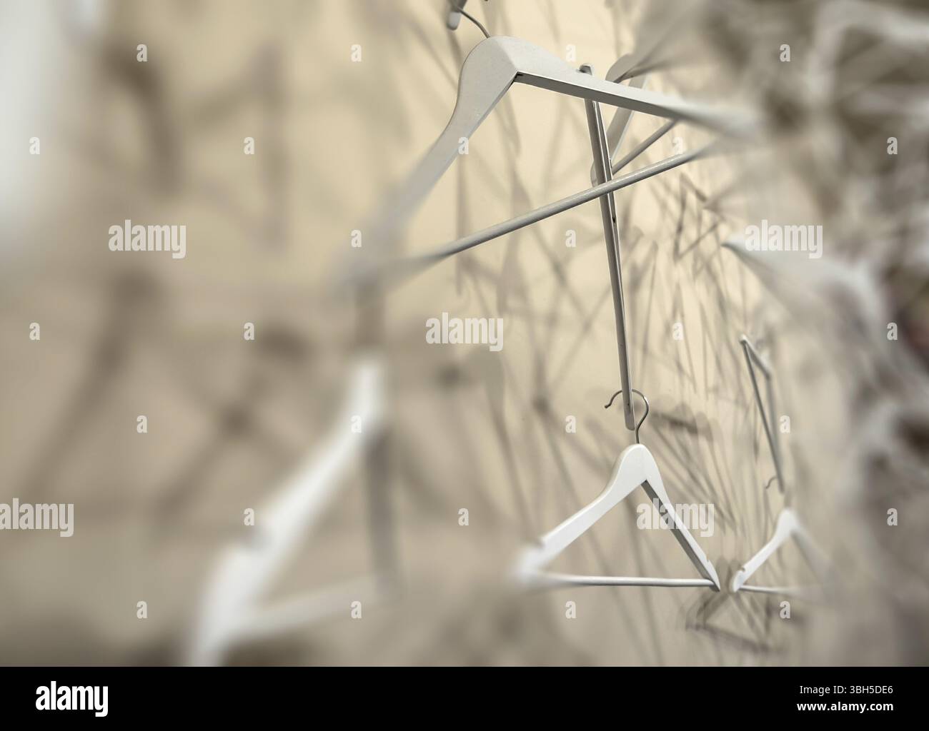 Appendiabiti vuoti in legno che proiettano ombre profonde. Appendiabiti in vero motivo in legno. Concetto astratto di moda. Messa a fuoco selezionata Foto Stock