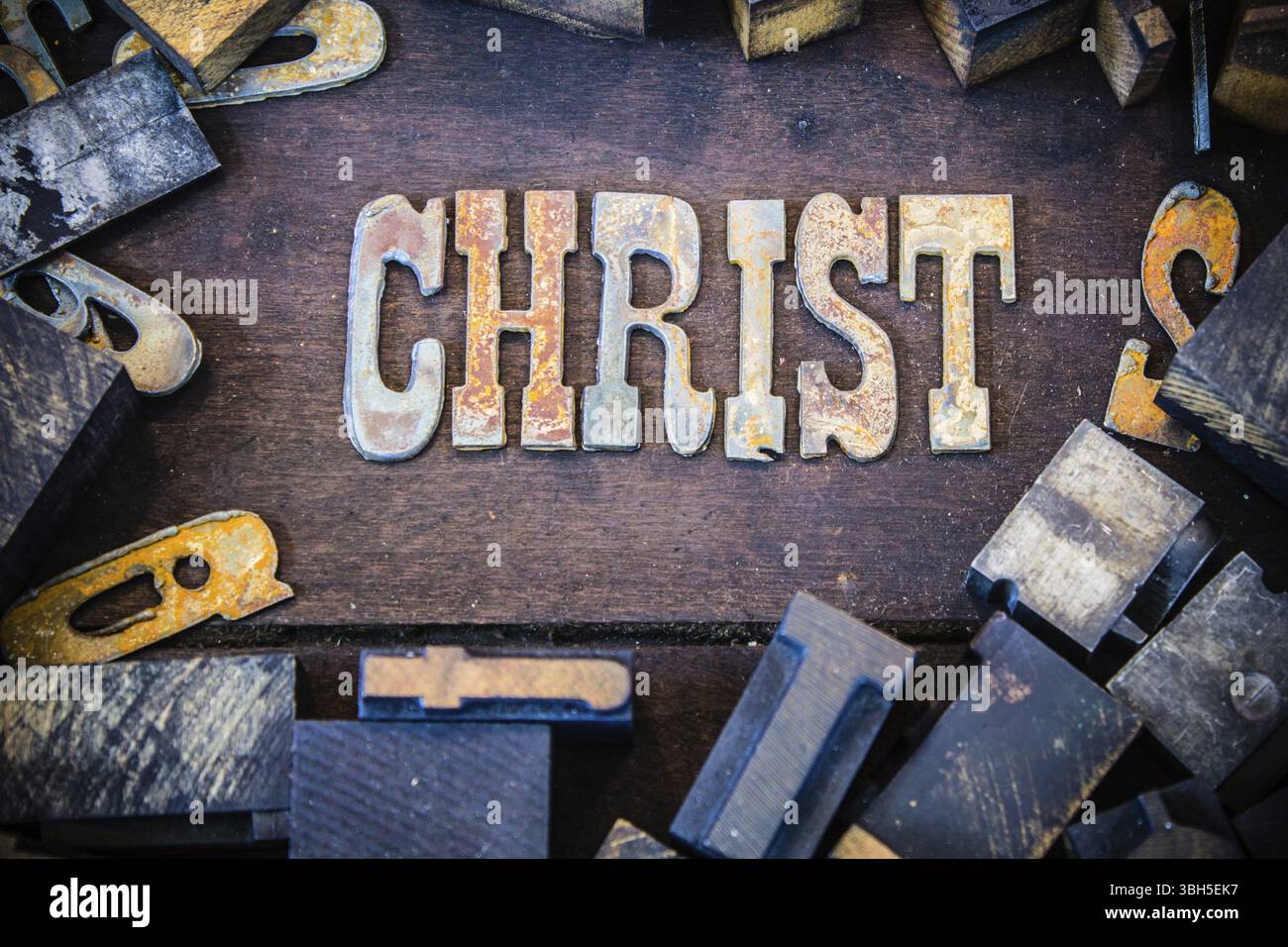 La parola CRISTO scritta in lettere di metallo arrugginito circondata da caratteri vintage in legno e metallo Foto Stock