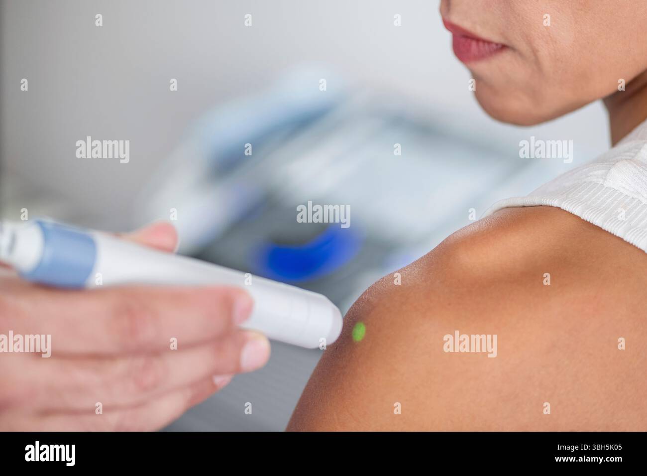 Il fisioterapista utilizza la terapia laser sulla spalla del paziente per alleviare il dolore e promuovere la guarigione. Il trattamento si concentra sul miglioramento della riparazione dei tessuti e sulla riduzione dell'infiammazione. Foto Stock