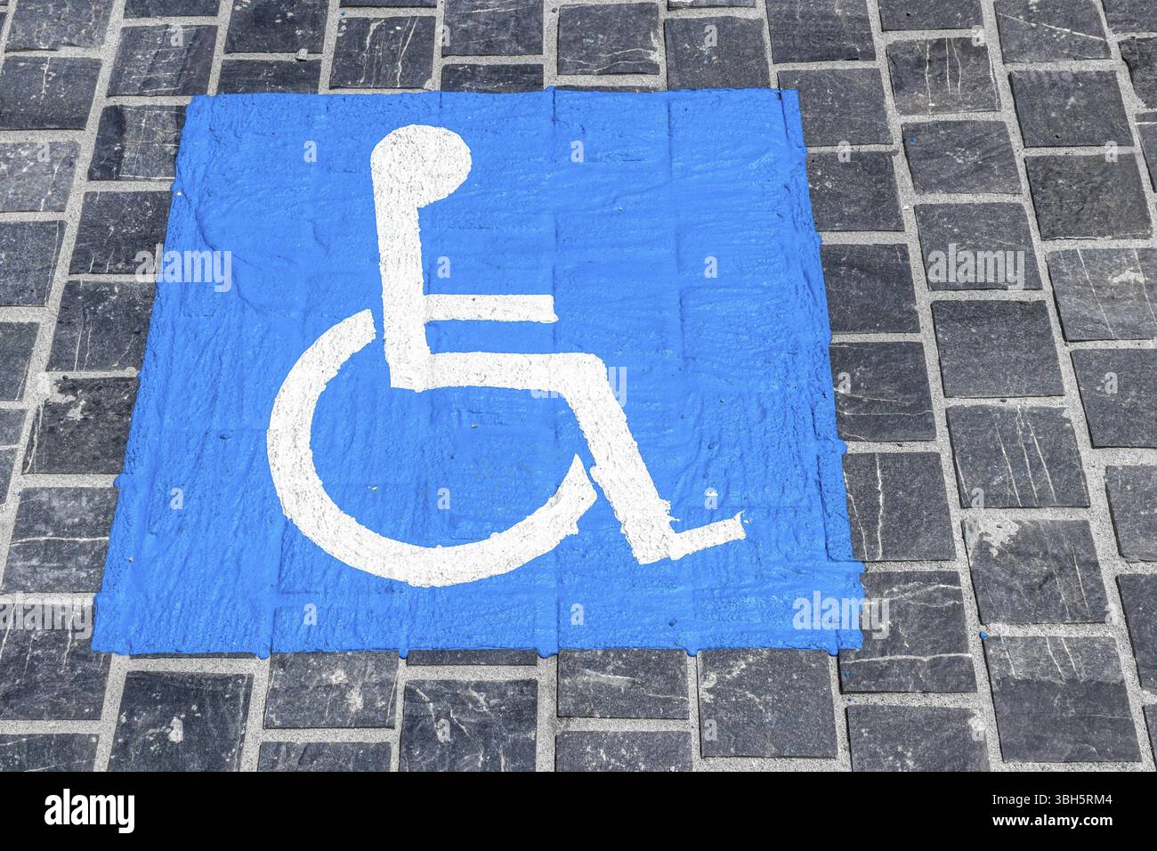 Un simbolo di handicap dipinto sulla strada di pietra Foto Stock