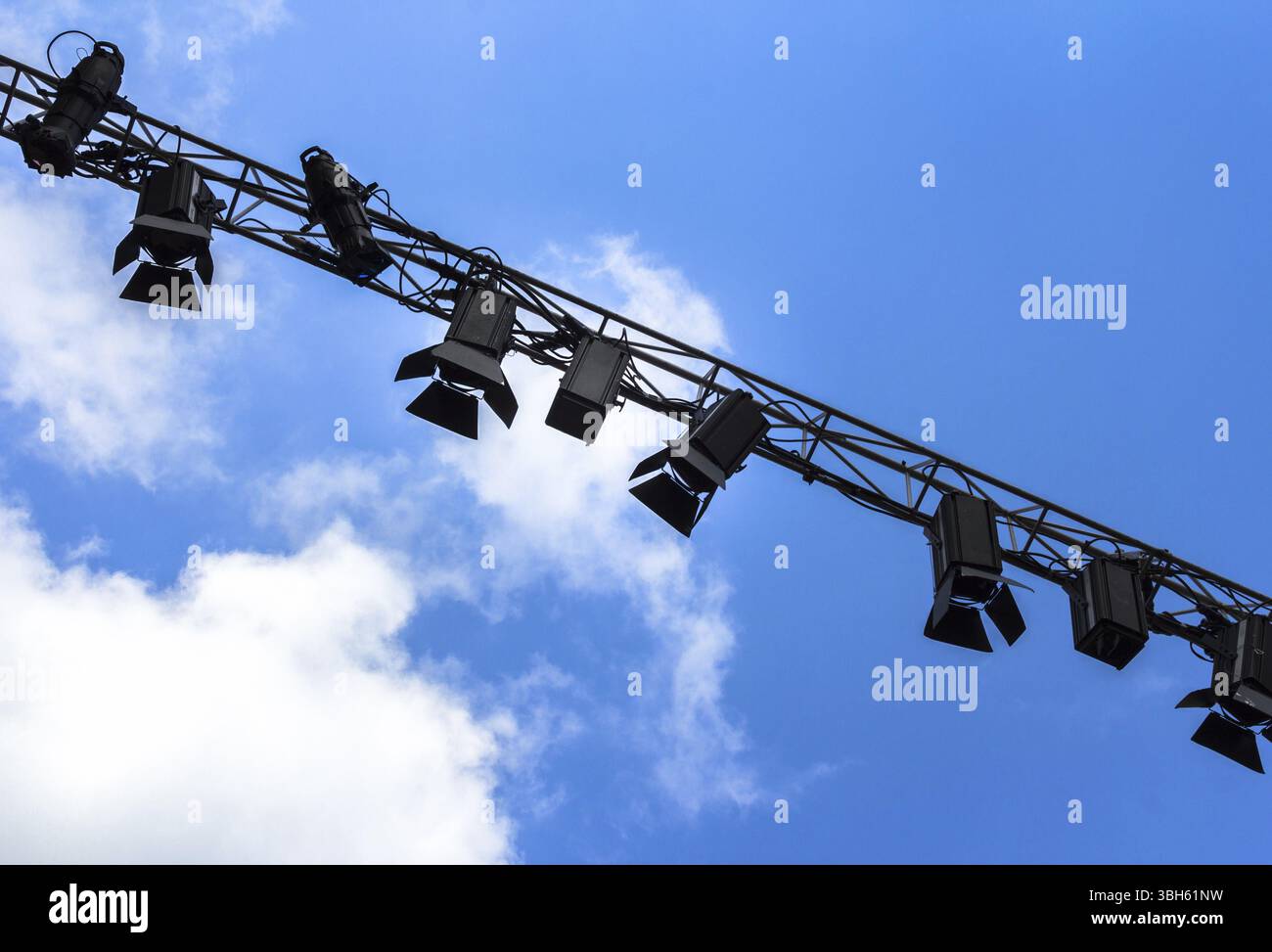 Faretti per palcoscenico all'aperto sulla struttura in metallo contro un cielo blu e nuvole Foto Stock
