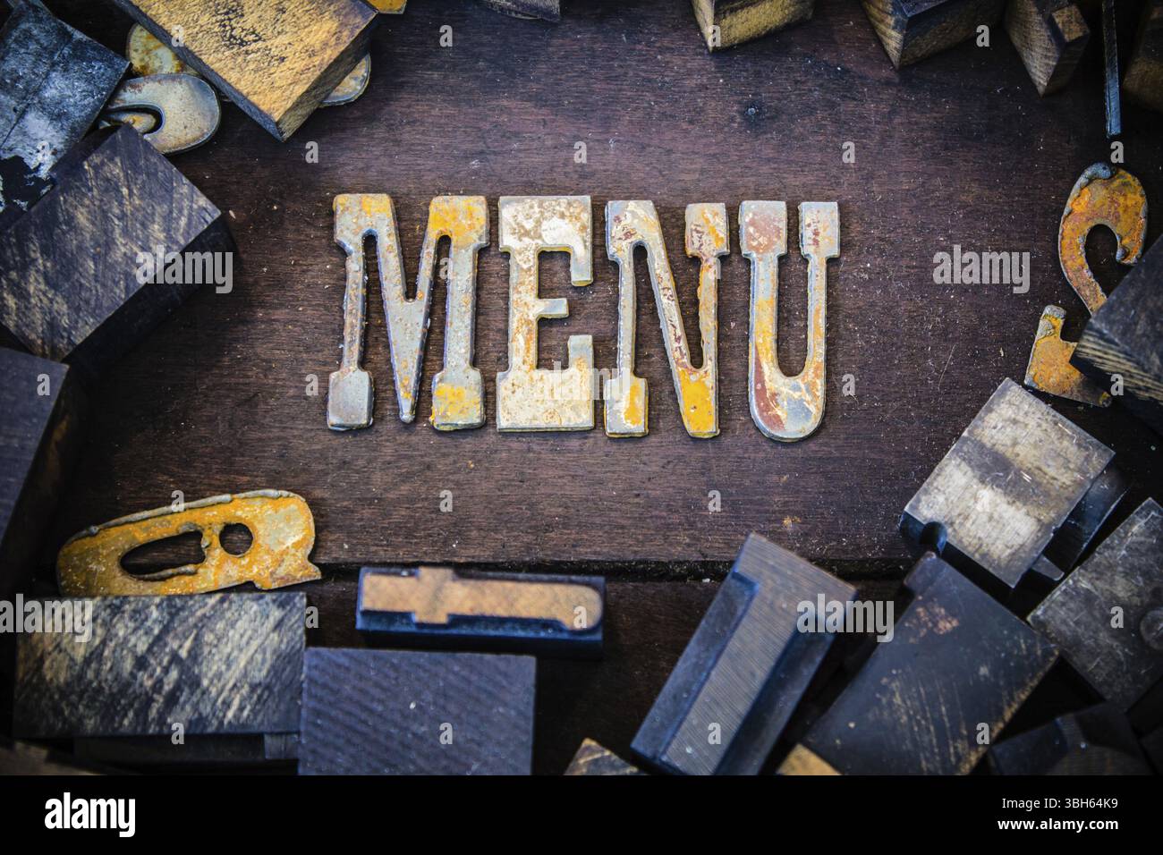 Il menu di parole è scritto in lettere di metallo arrugginito circondato da caratteri vintage in legno e metallo Foto Stock