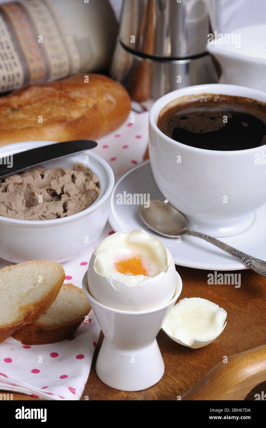 Uova bollite in pashotnitse per la colazione con una tazza di caffè e patè di fegato Foto Stock