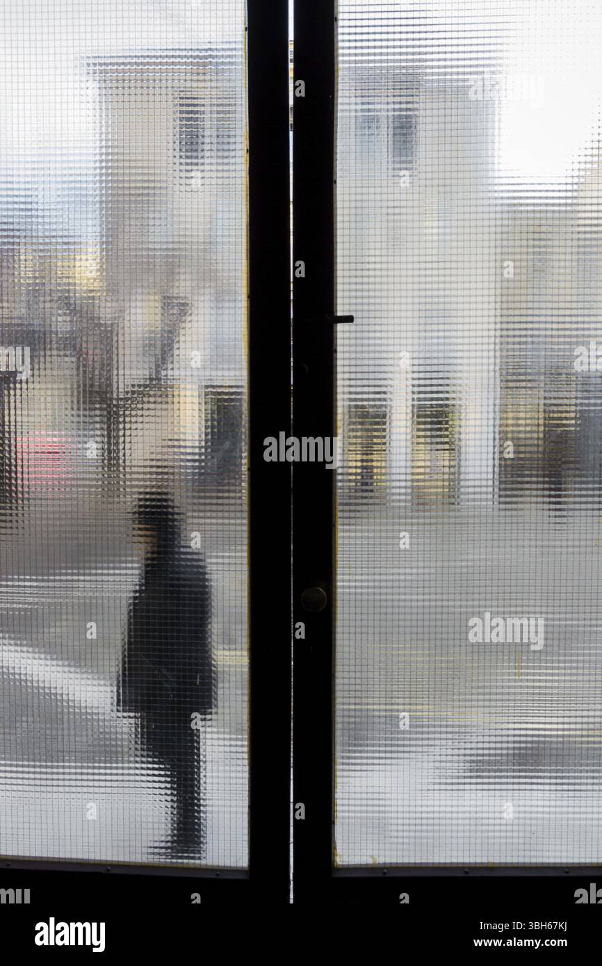 Una persona fuori dalla vecchia finestra. Foto sfocata. Colori sbiaditi Foto Stock