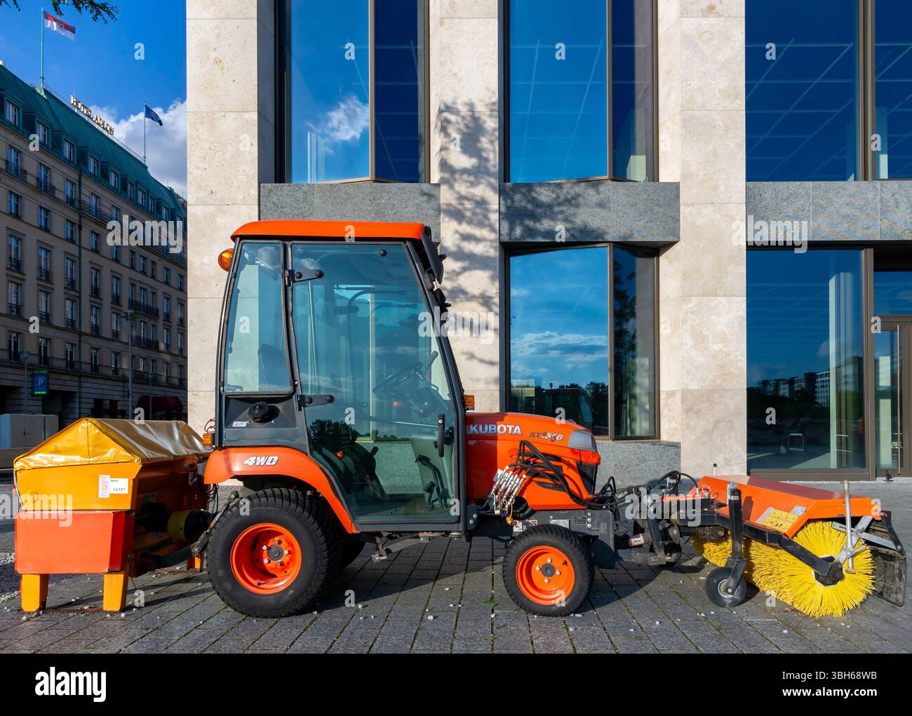Veicolo compatto Kubota BX2350 per la pulizia delle strade con spazzola anteriore parcheggiato nel centro di Berlino alla luce del sole. Foto Stock