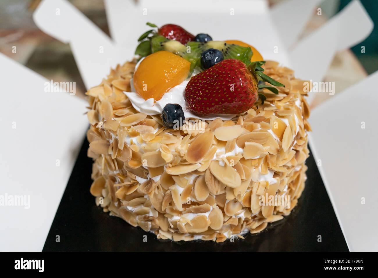 Questa è una vista ravvicinata di una torta alla frutta e alle mandorle con la scatola aperta. Foto Stock