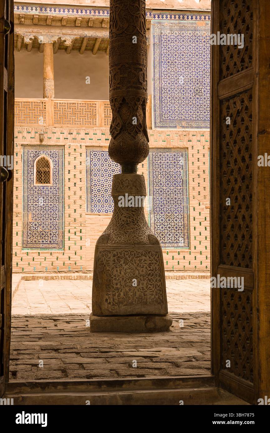 Colonna in legno scolpita nel Palazzo reale di Khiva - architettura tradizionale uzbeka Foto Stock