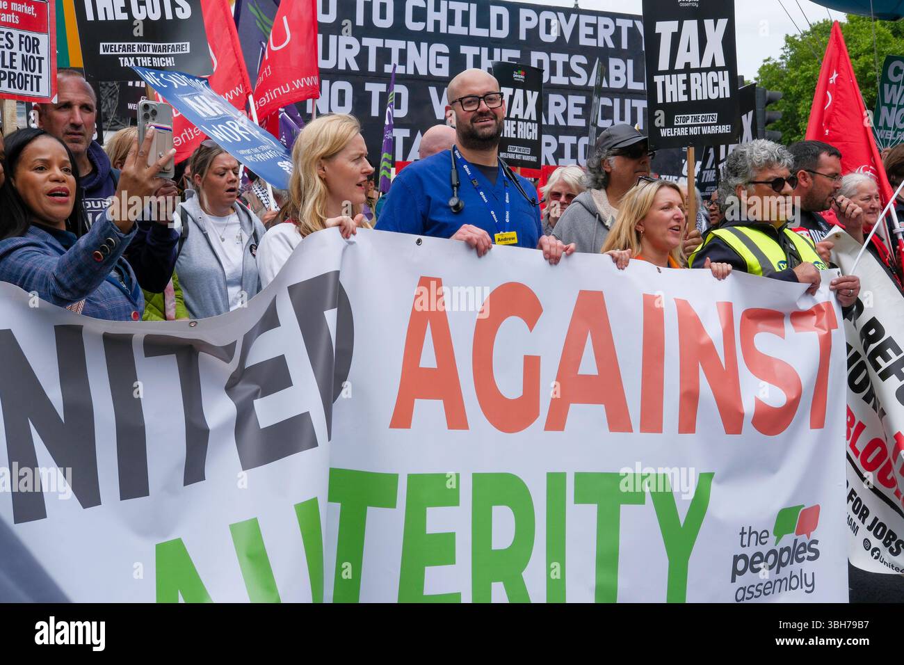 Londra, Regno Unito. 7 giugno 2025. La dimostrazione nazionale dell'Assemblea popolare. Migliaia di persone marciano attraverso il centro di Londra chiedendo la fine del servizio pubblico e dei tagli al welfare, nella prima grande marcia anti-austerità sotto il governo laburista britannico. Il gruppo di campagna People’s Assembly sta invitando il governo a “tassare i ricchi e la loro ricchezza nascosta per finanziare i servizi pubblici” con sindacalisti, salute, disabilità, alloggi e attivisti del welfare che si riuniscono sotto lo slogan: Basta austerità 2,0. Gli attivisti portano una bandiera unita contro l'austerità sulla rotta di marcia. Foto Stock