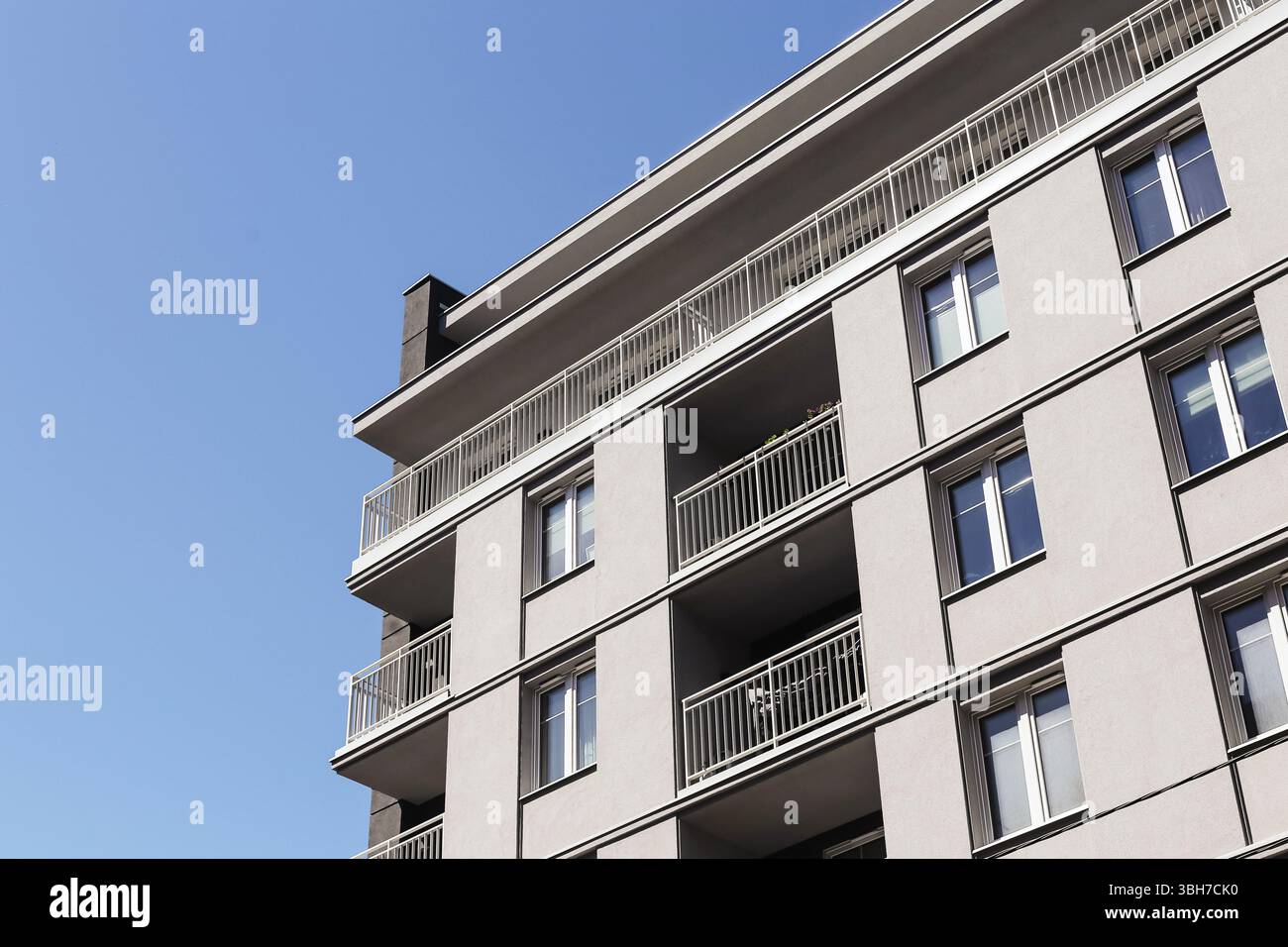 Facciata di un edificio residenziale grigio. Balconi abitativi urbani. Contesto degli investimenti immobiliari. Muro esterno dell'appartamento. Moderna architettura cittadina. Foto Stock