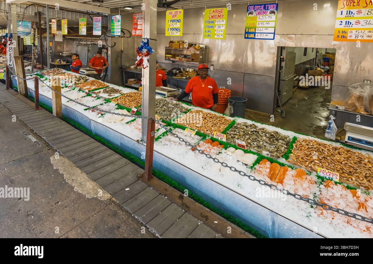 Washington D.C., USA - 24 maggio 2025. Banchi di pesce ghiacciato pieni di gamberi, pesce e molto altro presso il vivace mercato del pesce di Maine Avenue. Foto Stock