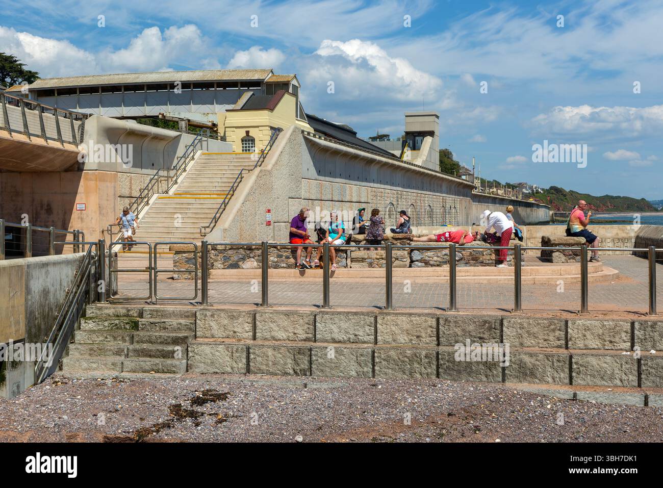 Gente che gode del sole sul lungomare di Dawlish, nel Devon meridionale, Inghilterra, Regno Unito Foto Stock