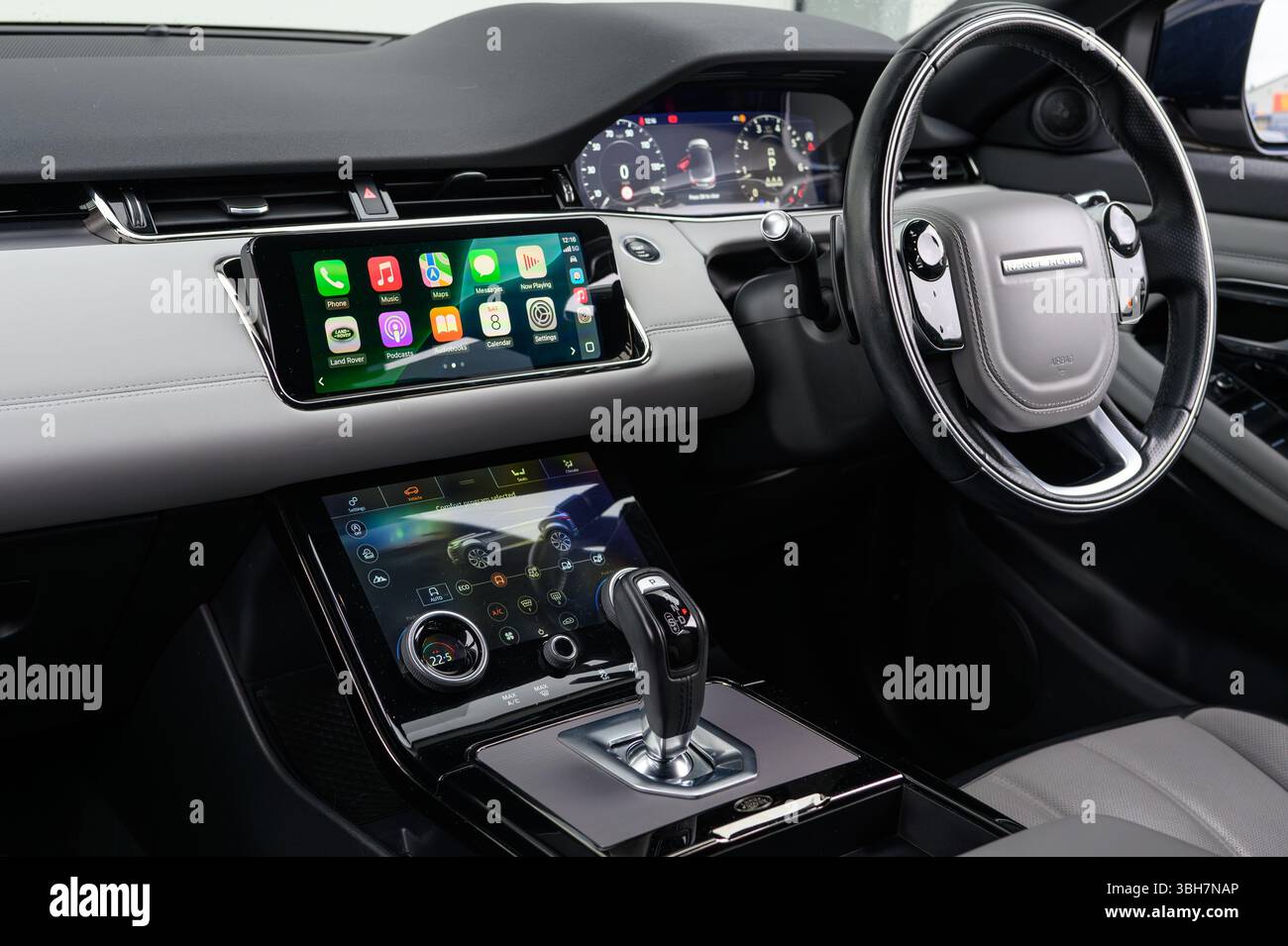 Questa immagine mostra gli interni sofisticati di una Range Rover, evidenziando il touch screen di informazione e intrattenimento con Apple CarPlay attivo, che unisce Premium Foto Stock