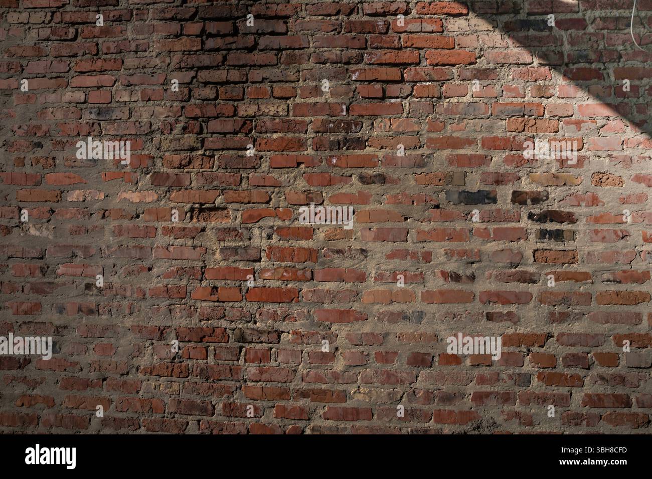 Muro di mattoni rossi ruvidi con Malta e ombra irregolari. Sfondo di texture urbane per costruzioni, ristrutturazioni o temi di design rustico. Foto Stock Muro di mattoni rossi ruvidi con Malta e ombra irregolari. Sfondo di texture urbane per costruzioni, ristrutturazioni o temi di design rustico. Foto Stock