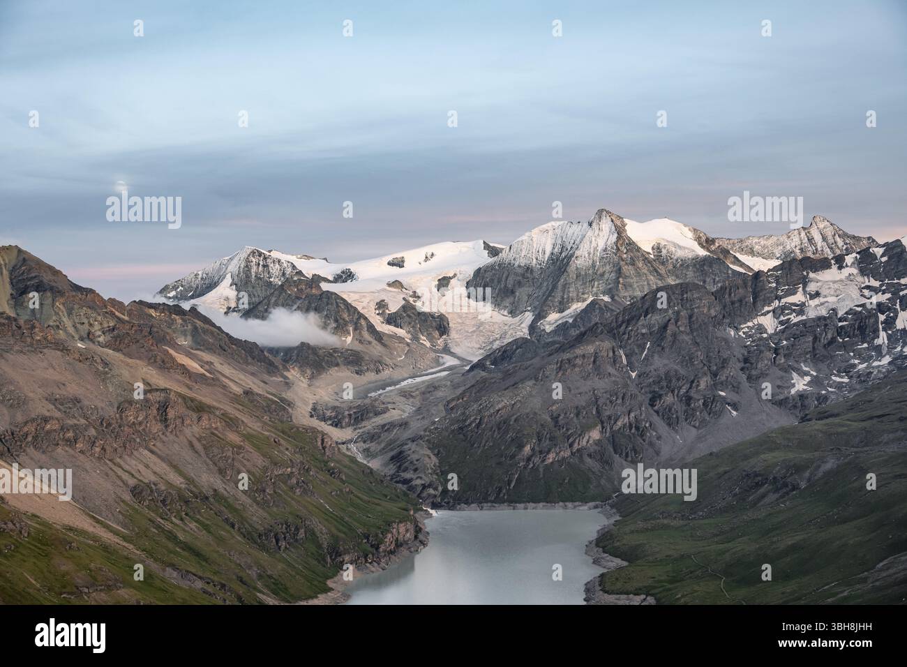 Paesaggio montano con il lago artificiale blu turchese Lac des Dix e la cima del Monte bianco de Cheilon, la luna sopra le vette al tramonto, Hermenence, Vala Foto Stock