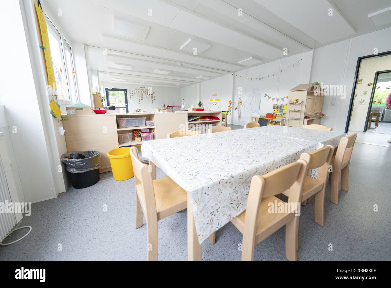 Invitante area tavolo nell'asilo con decorazioni e giocattoli, centro diurno in container di transizione, centro diurno di Gechingen, quartiere Calw Foto Stock