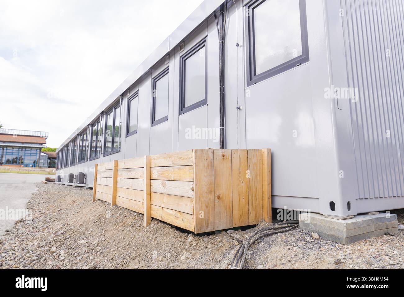 Vista laterale di un edificio modulare con pannelli e finestre in legno, centro diurno di transizione nella costruzione di container, centro diurno di Gechingen, CA Foto Stock