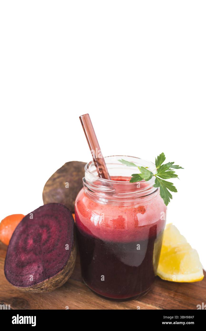 Un frullato vivace a base di barbabietola, carote e limone servito in un bicchiere trasparente. Ricca di antiossidanti e nutrienti, questa bevanda colorata supporta l'auto Foto Stock