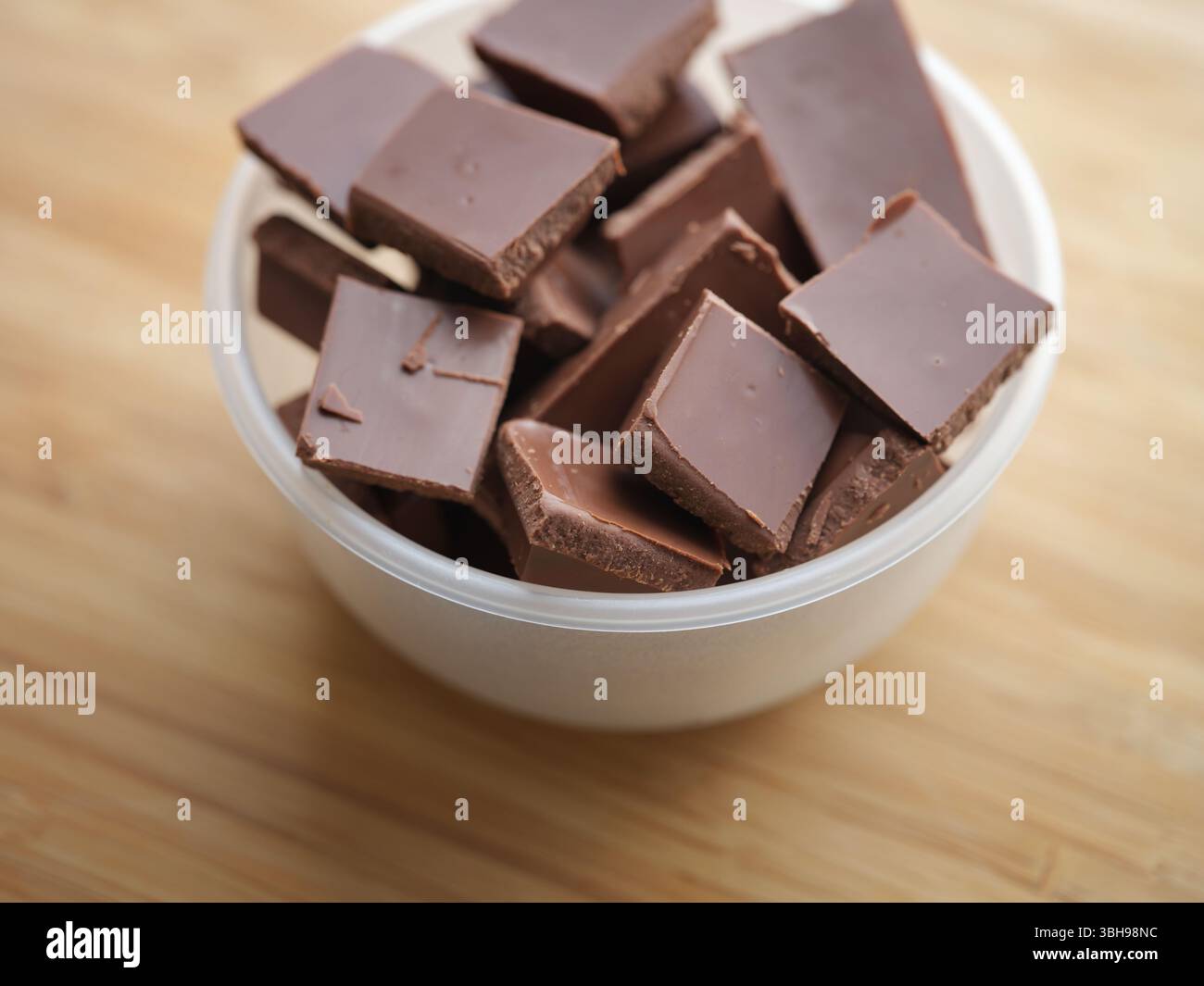 Un mucchio di cioccolato al latte rotto in una ciotola. Profondità di campo ridotta. Primo piano. Foto Stock