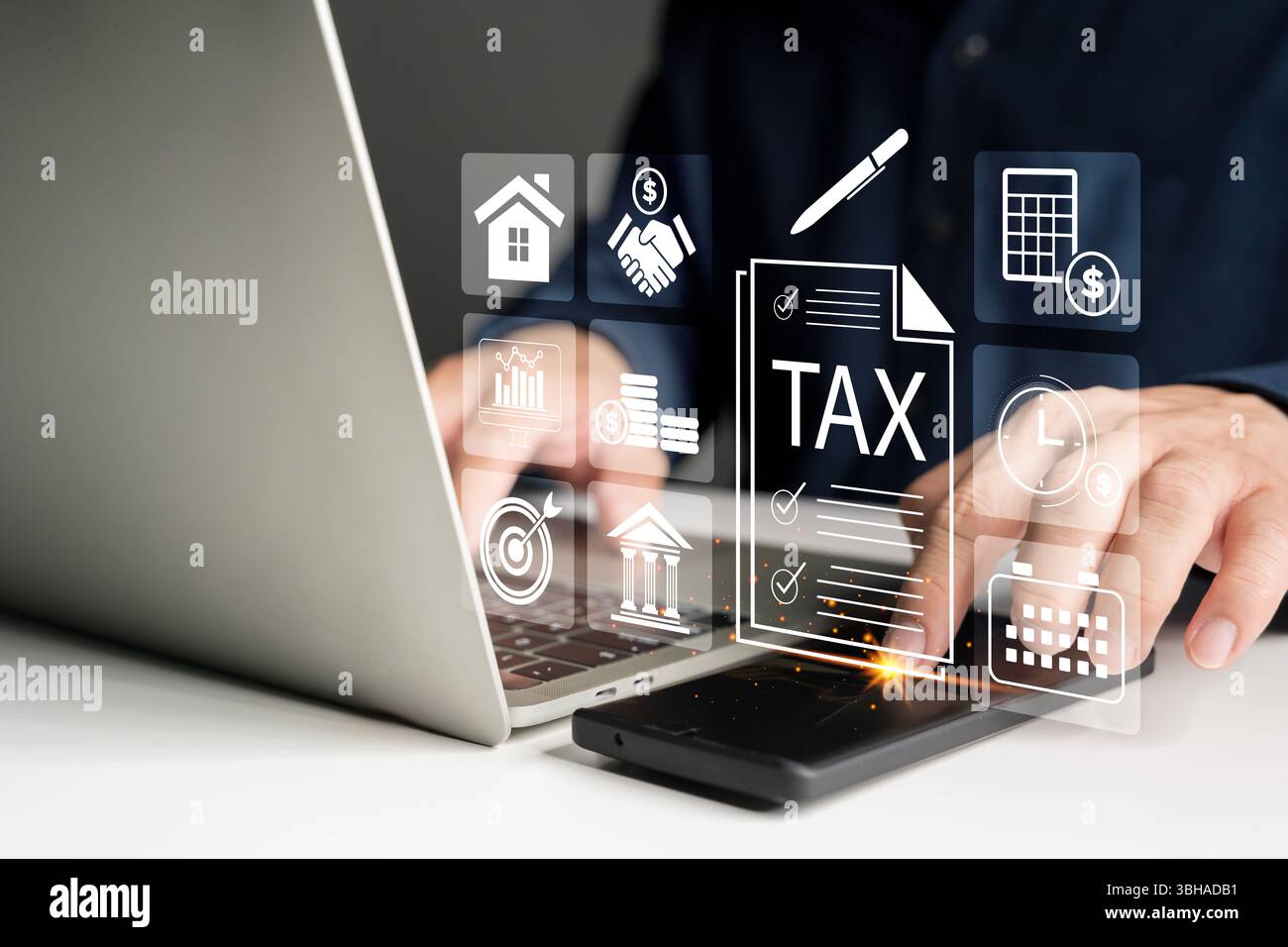 Uomo d'affari che utilizza un computer portatile e uno smartphone per la compilazione digitale delle imposte, la gestione finanziaria e la contabilità. Le icone fiscali virtuali e gli strumenti online rappresentano finan Foto Stock