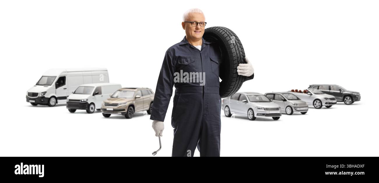 Meccanico di auto in un parcheggio con pneumatici e chiave isolata su sfondo bianco Foto Stock