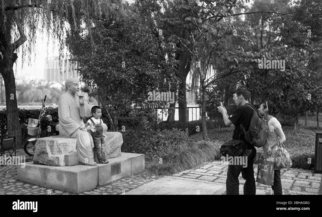 Alla fine degli anni '2000, i genitori di Hangzhou Street fotografano il bambino con il telefono cellulare, Zhejiang Cina Foto Stock