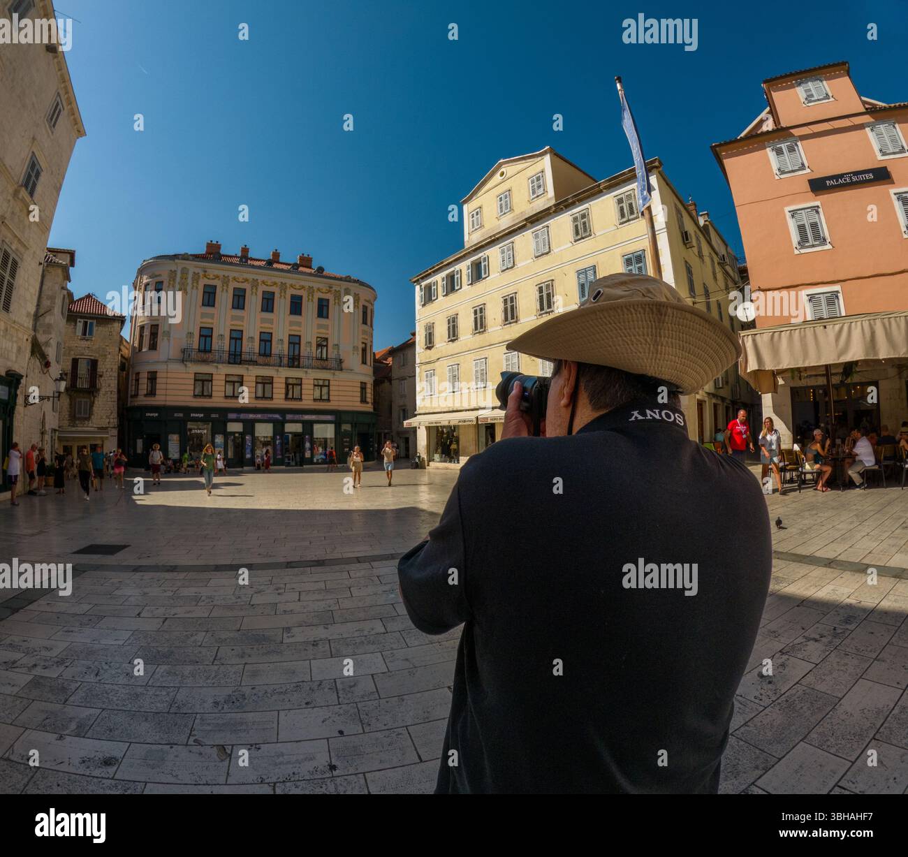 Spalato, Croazia - 8 settembre 2023: Un fotografo cattura la vibrante scena della piazza del Palazzo di Diocleziano, piena di turisti e vita locale. Foto Stock
