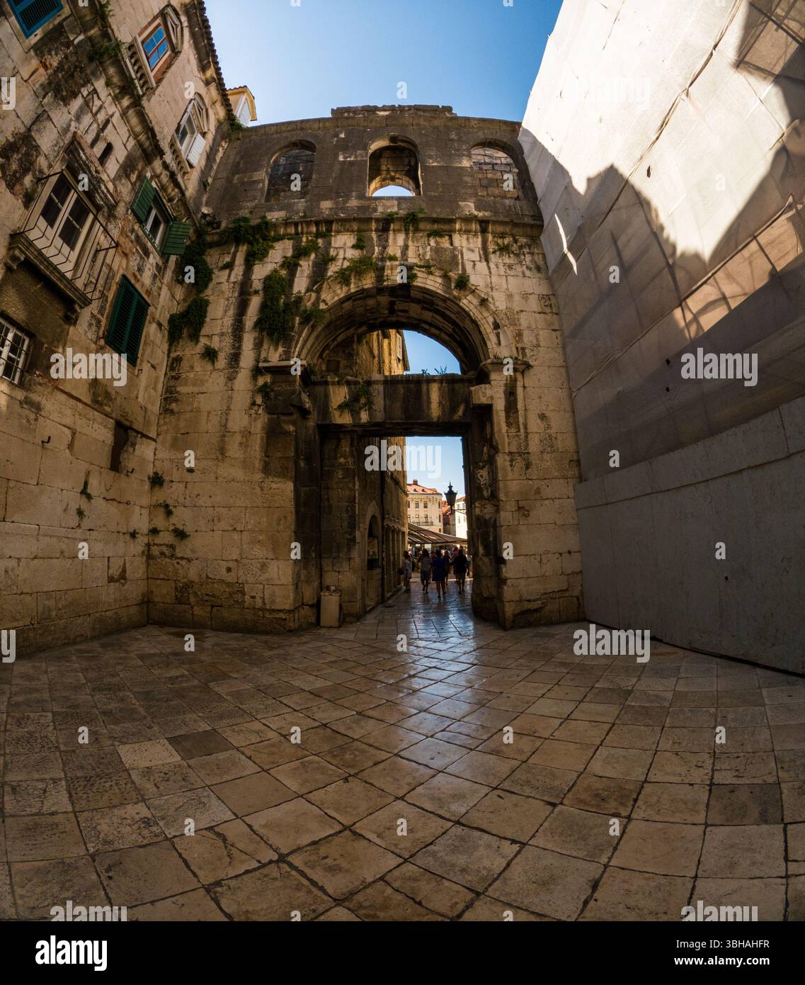 Spalato, Croazia - 8 settembre 2023: I turisti esplorano il Palazzo di Diocleziano, patrimonio dell'umanità dell'UNESCO, camminando attraverso l'antica arcata in pietra. Foto Stock