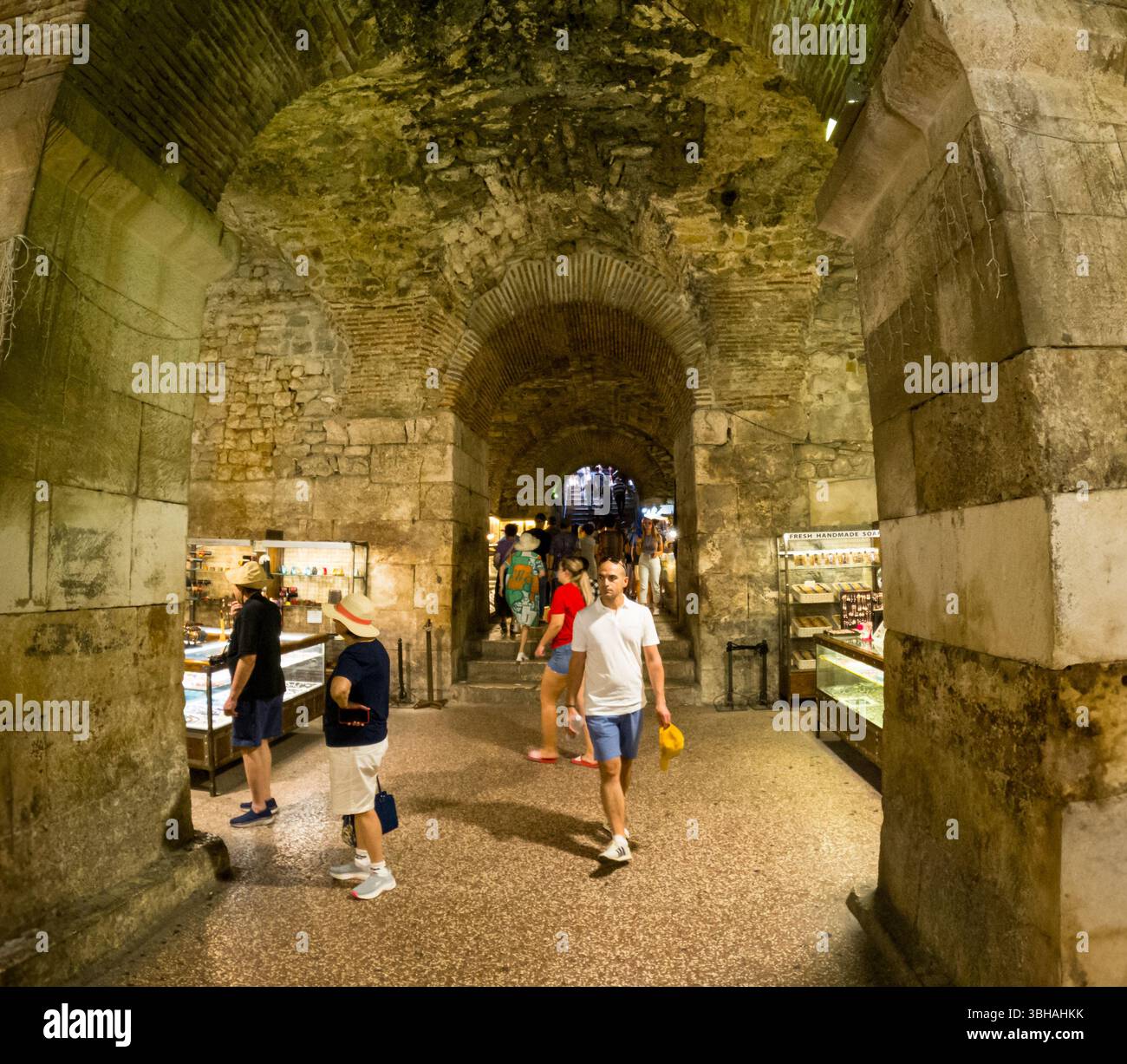 Spalato, Croazia - 8 settembre 2023: I turisti esplorano le antiche cantine del Palazzo di Diocleziano, ora fiancheggiate da negozi, un'attrazione popolare. Foto Stock