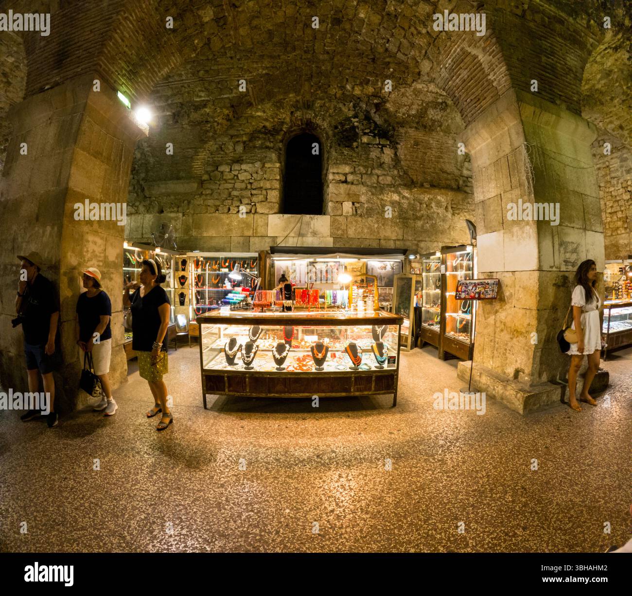 Spalato, Croazia - 8 settembre 2023: I turisti curiosano tra gioielli e souvenir nelle antiche cantine del Palazzo di Diocleziano, un popolare luogo per lo shopping. Foto Stock