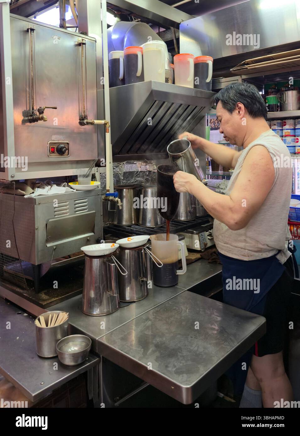 Preparare il tè al latte in stile HK al LAN Fong Yuen è una famosa casa di tè al latte in stile Hong Kong in Gage Street a Hong Kong. Foto Stock