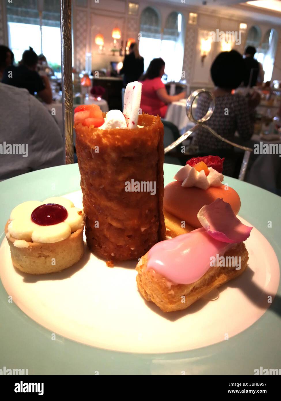 Elegante esposizione di pasticceria assortita su un piatto nell'ambiente Cafe'. Londra, Regno Unito Foto Stock