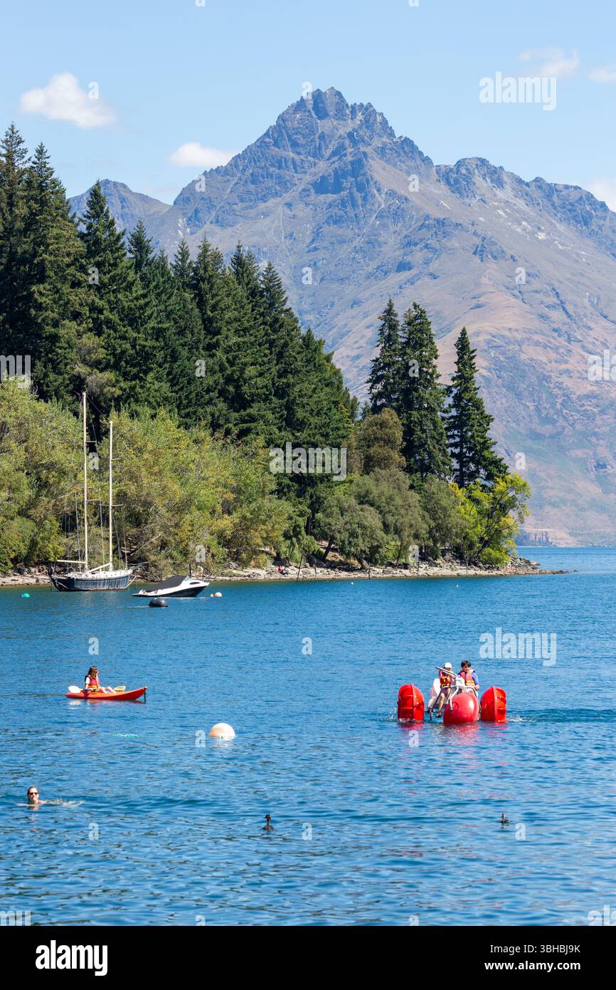 Gente che pratica sport acquatici a Queenstown Bay con Cecil Peak sullo sfondo, Lake Wakatipu, Queenstown, Otago, nuova Zelanda Foto Stock