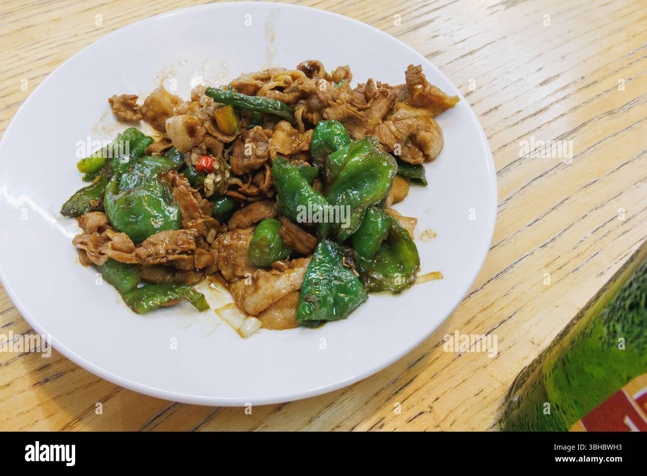 Cibo cinese, pancetta di maiale a fette e frittura con peperoni verdi Foto Stock