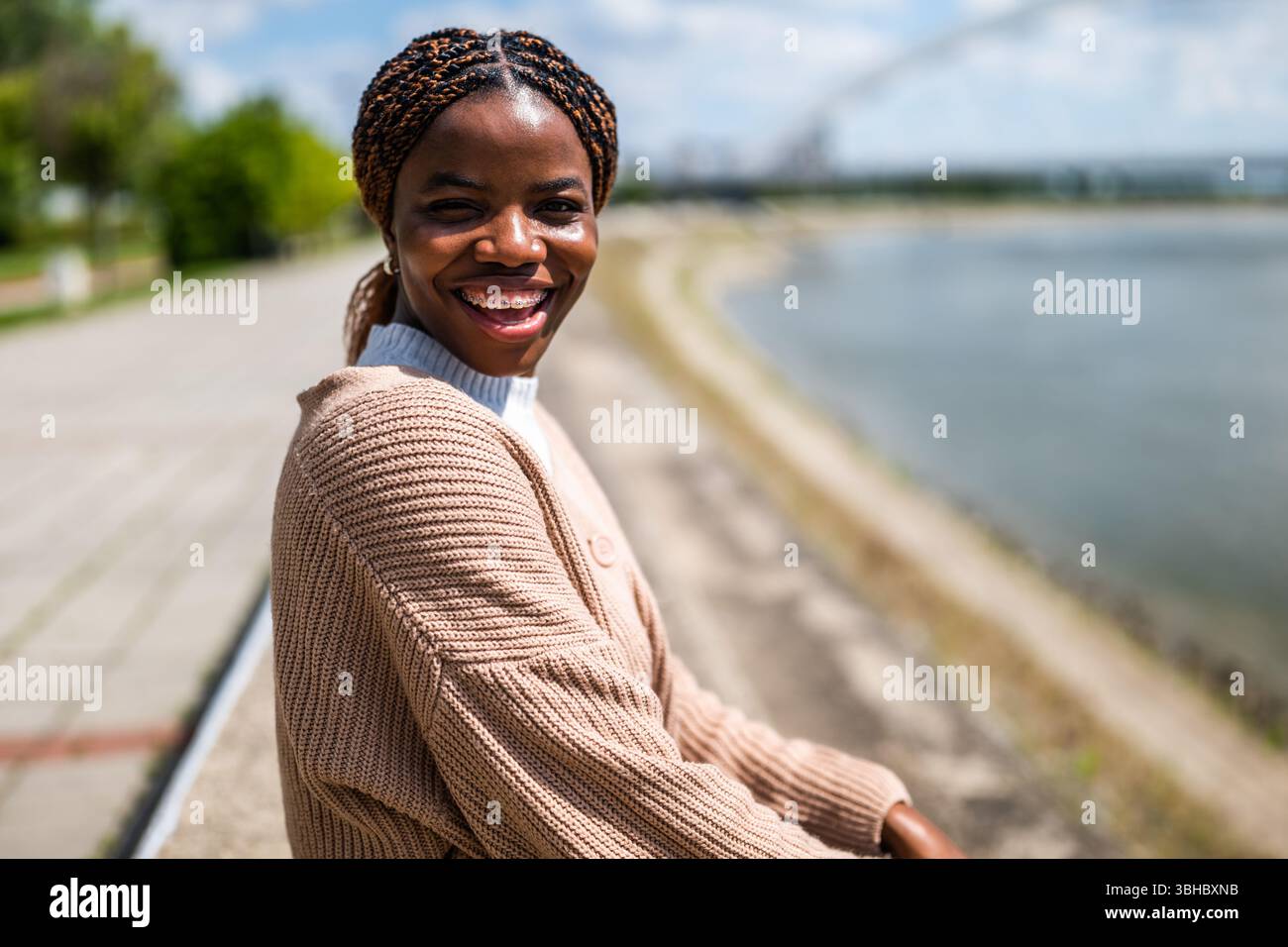 Ritratto di una giovane donna nera allegra che si gode una giornata di sole in città. Foto Stock