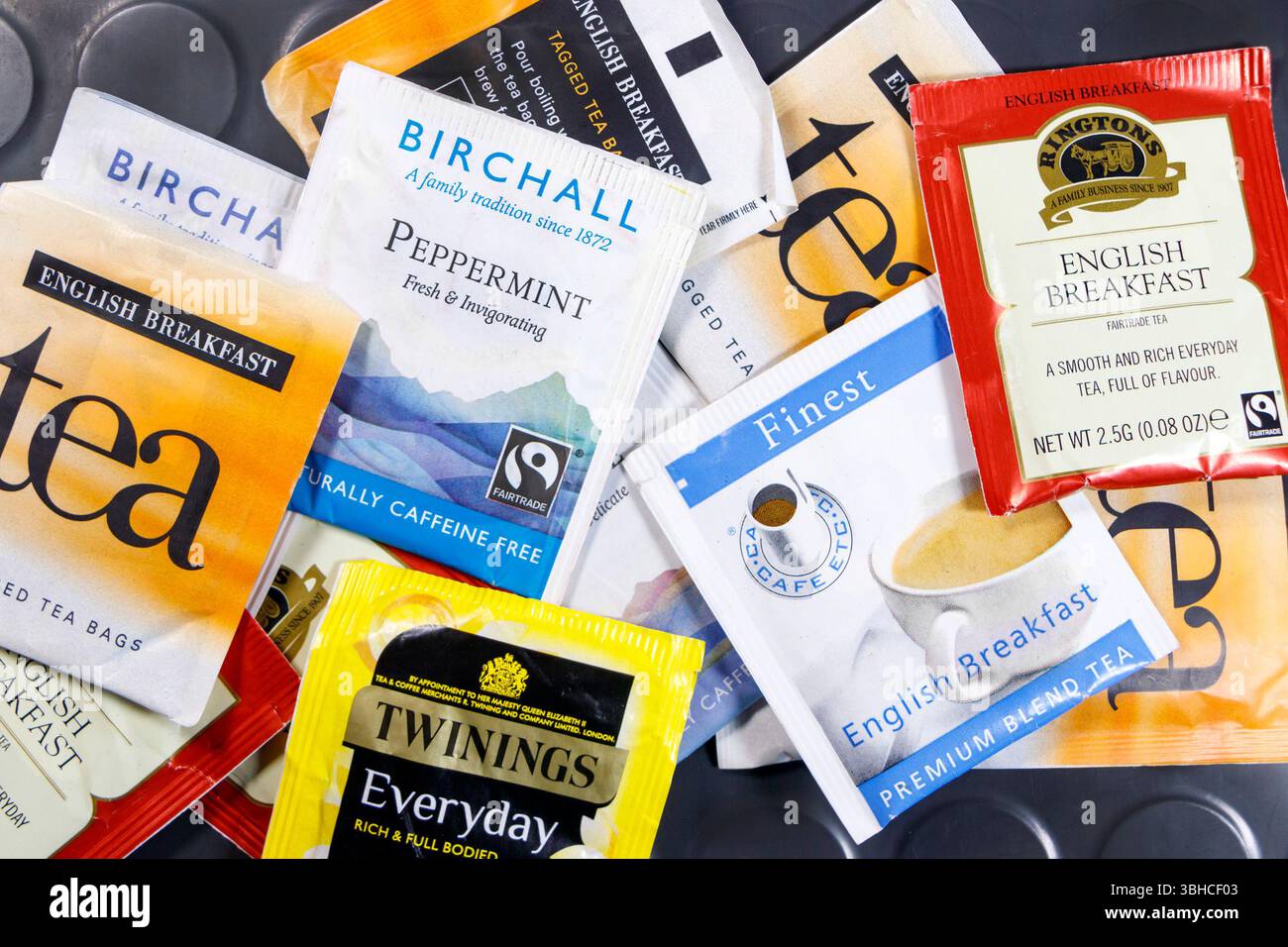 Collezione di varie bustine di tè all'inglese per la colazione, tra cui Birchall, Ringtons e i migliori su un tavolo grigio. Foto Stock