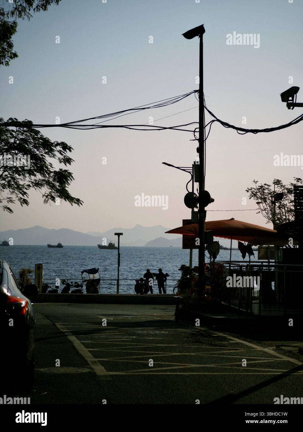 Vista serale della strada con mare e sagome a Guanhu, Shenzhen - Immagine stock catturata con smartphone