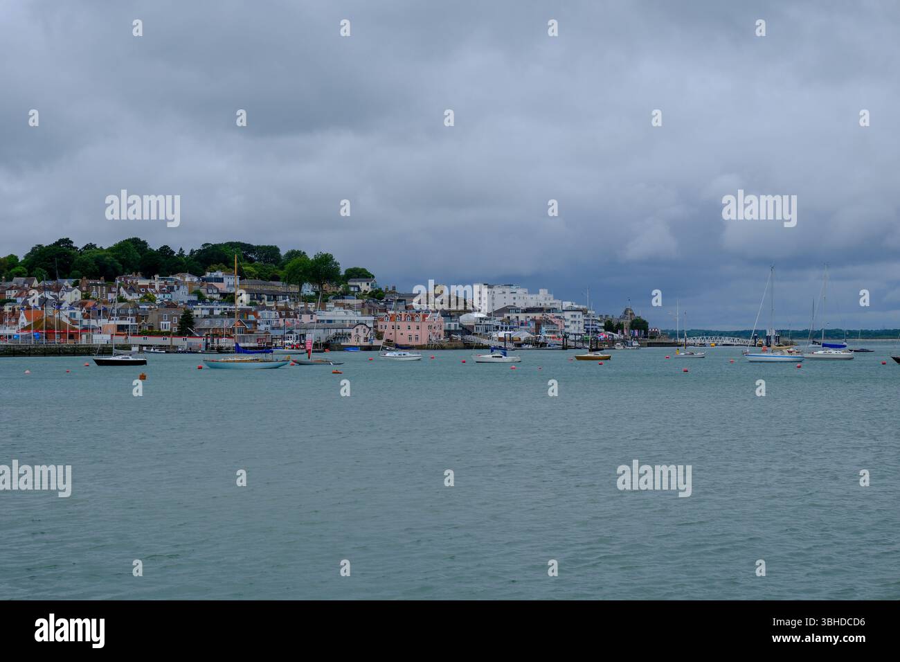 07 giu 2025 - Cowes, Isola di Wight - Una vista di Cowes, Isola di Wight, dall'altra parte della costa in una tipica giornata piovosa e piovosa. Foto Stock