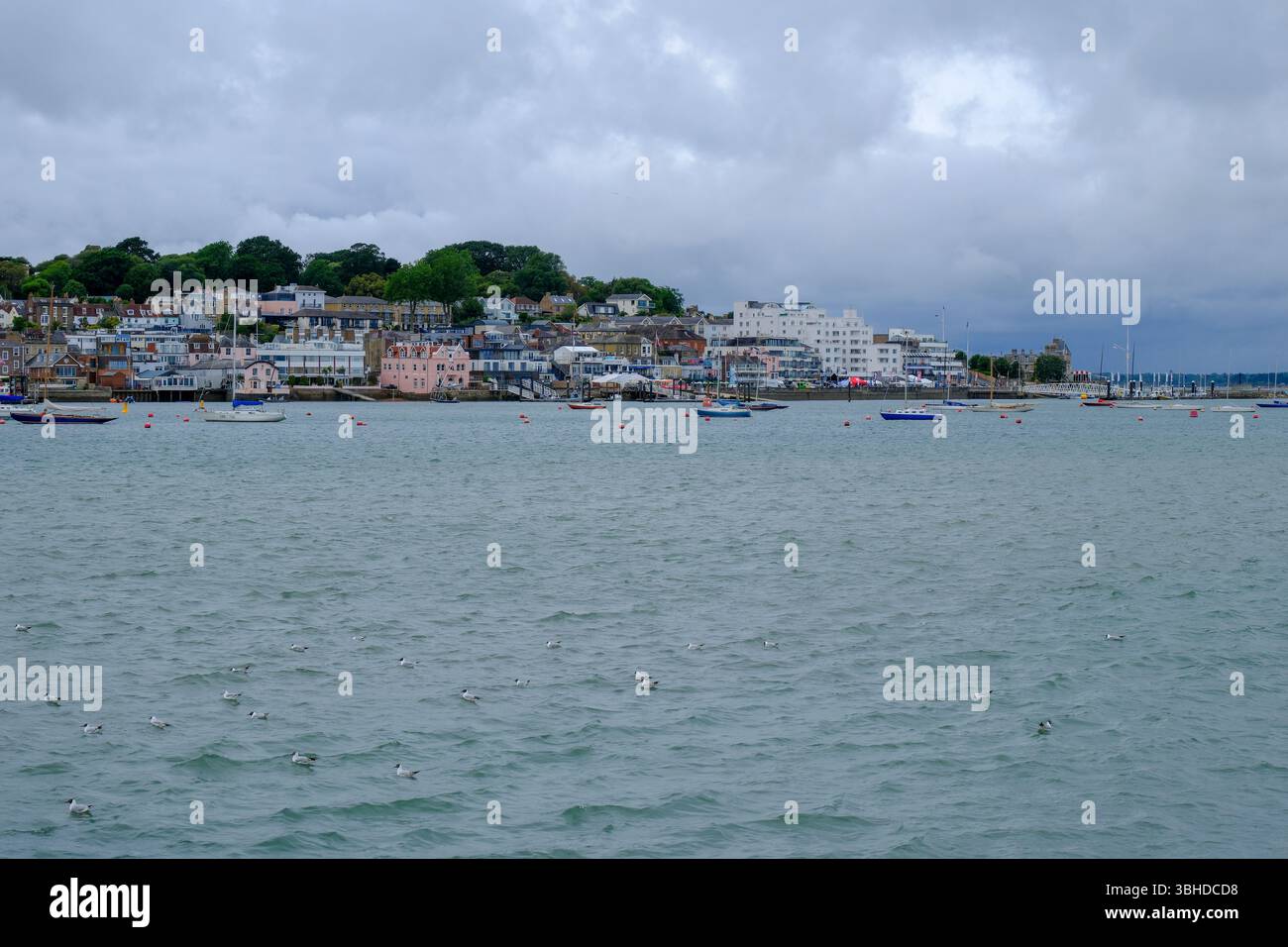 07 giu 2025 - Cowes, Isola di Wight - Una vista di Cowes, Isola di Wight, dall'altra parte della costa in una tipica giornata piovosa e piovosa. Foto Stock