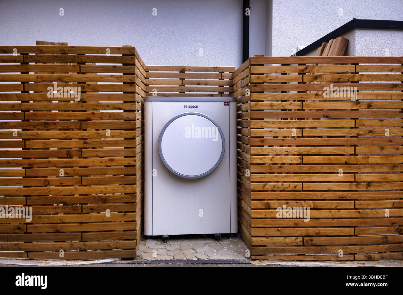 Pompa di calore aria-acqua Bosch compress 7400i AW, logo, unità esterna, servizi edili, in piedi di fronte alla recinzione del giardino, recinzione in legno, incavo, Stoccarda Foto Stock
