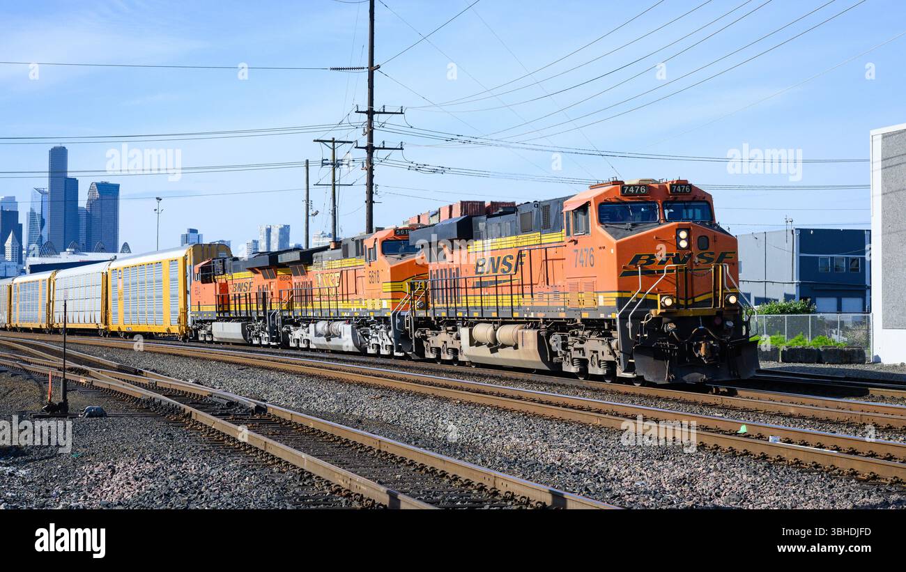 Seattle - 23 maggio 2025; la locomotiva arancione della BNSF conduce il treno a cremagliera auto attraverso Seattle Foto Stock