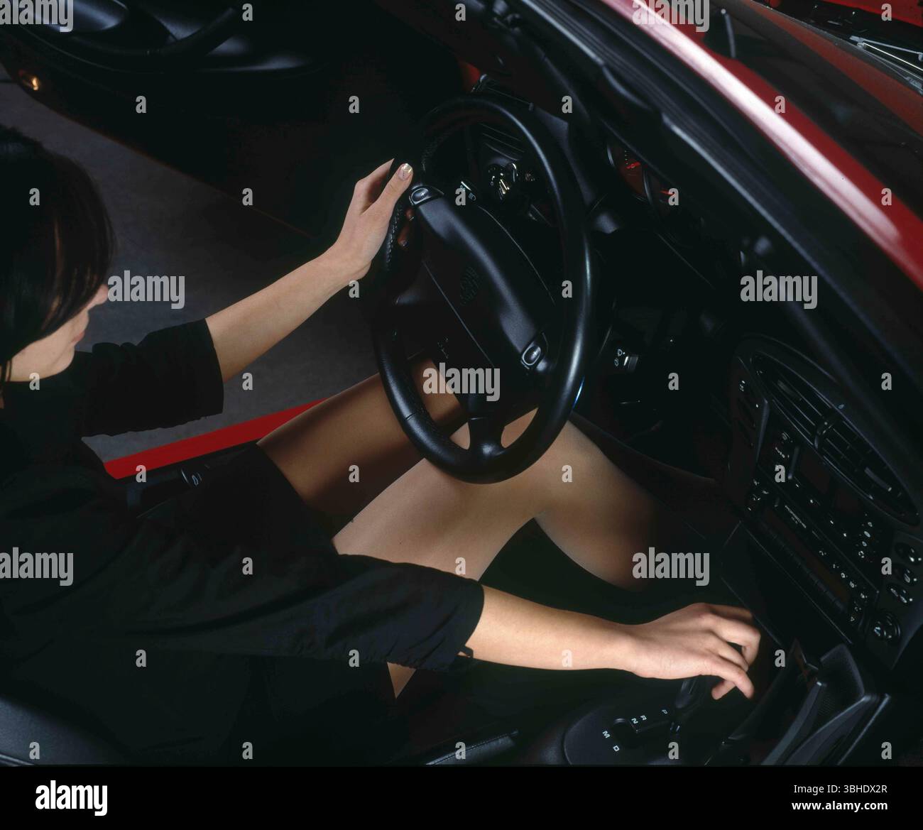 Una bella giovane donna, pilota della volan, cambia marcia Foto Stock