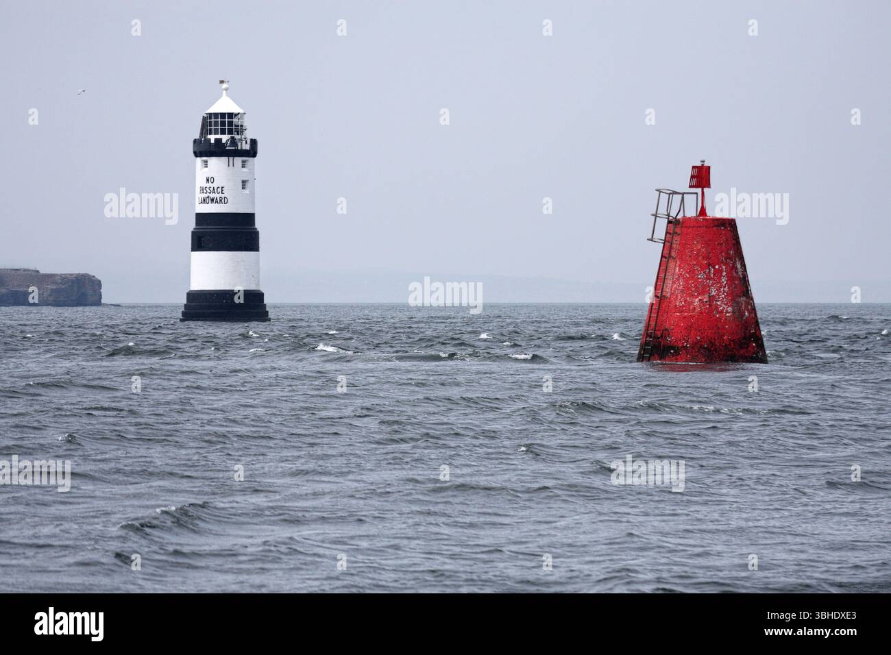 Faro di Trwyn Du a Penmon Point, vicino all’isola di Puffin sulla costa di Anglesey, Galles, con la dicitura «nessun passaggio verso terra» Foto Stock