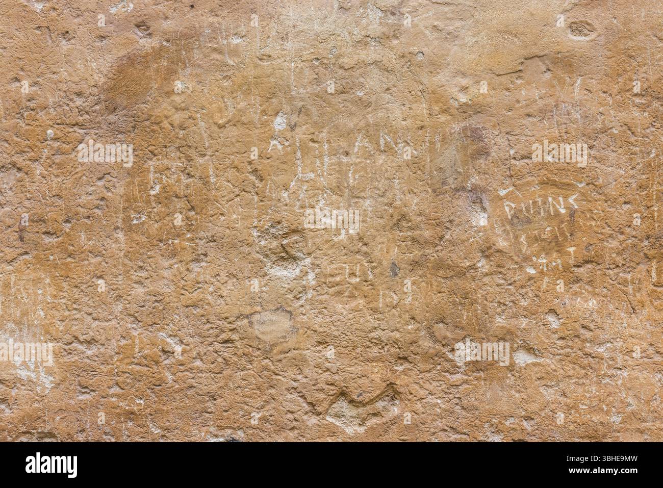 Dettaglio di texture su pareti in pietra intemprata con scritte storiche incise sulla superficie. Oxfordshire, Regno Unito. Foto Stock