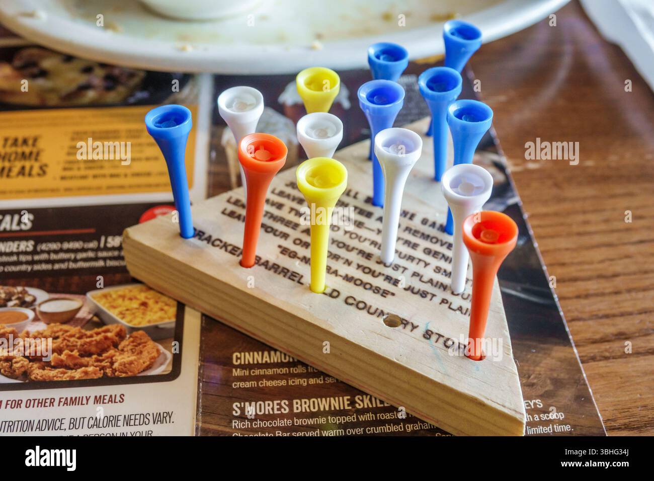 Fort ft. Pierce Florida, ristorante Cracker Barrel Old Country Store, interno, menu a triangolo, puzzle da tavolo con pioli di legno, giallo arancio bianco blu Foto Stock